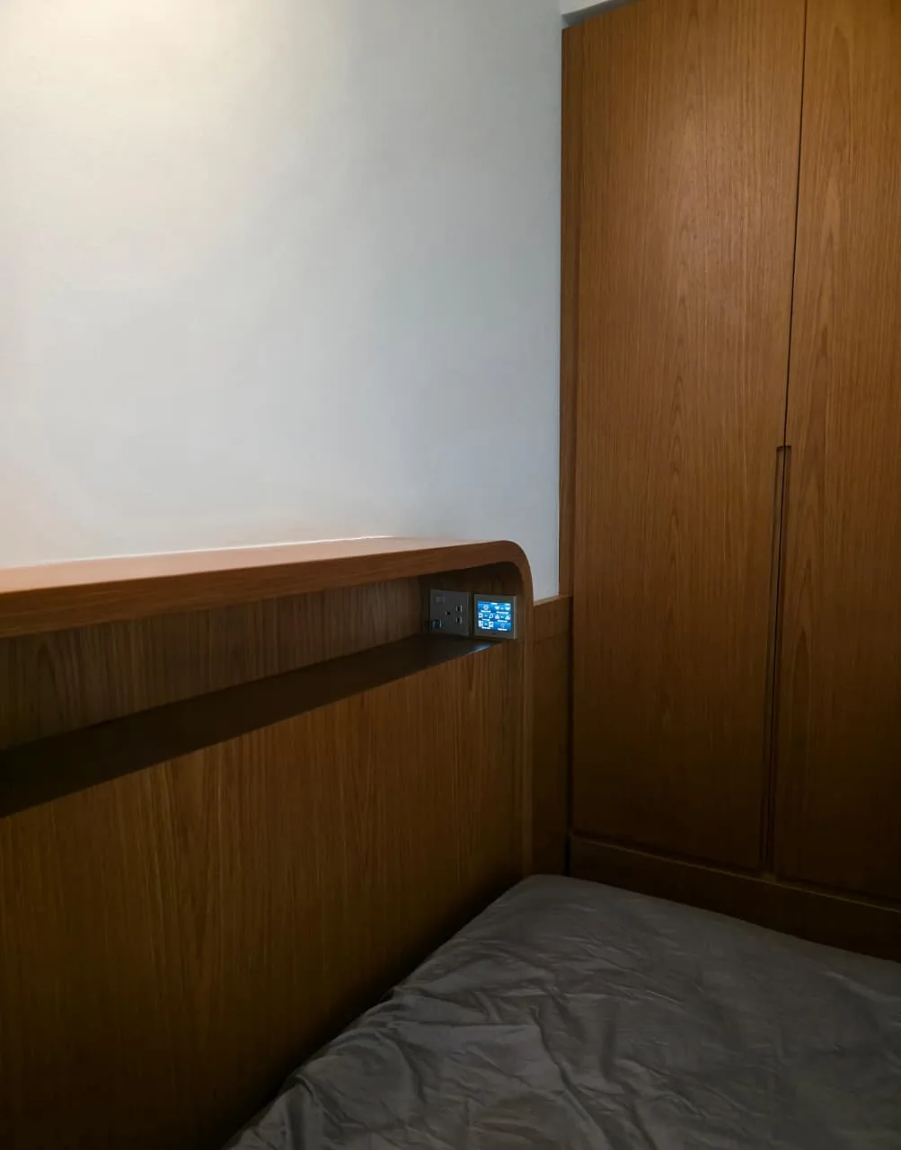 Bedroom wall with a small illuminated control panel in a Dubai villa